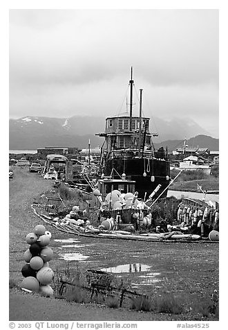 Retired fishing boat with a pile of marine gear on the Spit. Homer, Alaska, USA