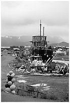 Retired fishing boat with a pile of marine gear on the Spit. Homer, Alaska, USA (black and white)