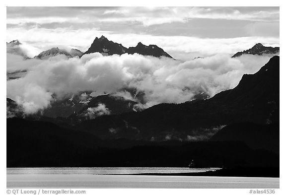 Mountains rising above bay with low clouds. Homer, Alaska, USA