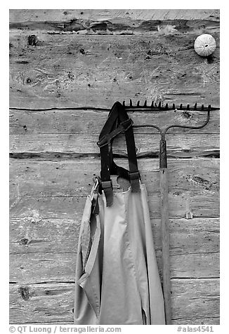 Waders hanging on a cabin wall. Ninilchik, Alaska, USA (black and white)