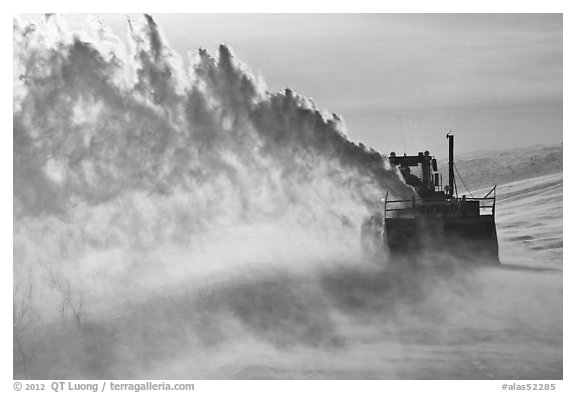 Winter service vehicle blowing snow out of road. Alaska, USA