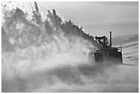 Winter service vehicle blowing snow out of road. Alaska, USA (black and white)