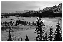 Winter landscape with frozen river at sunset. Alaska, USA (black and white)