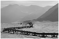 Alaska Pipeline snaking below Arctic Brooks mountains in winter. Alaska, USA ( black and white)