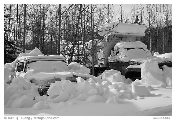 Trucks covered with piles of snow. Wiseman, Alaska, USA