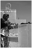 Sculptor using electric saw to carve ice. Fairbanks, Alaska, USA (black and white)