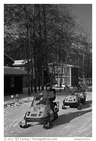 Snomobiler next to resort buildings. Chena Hot Springs, Alaska, USA (black and white)