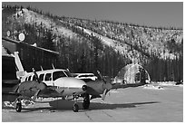 Plane with engine block warmers on frozen runway. Chena Hot Springs, Alaska, USA (black and white)