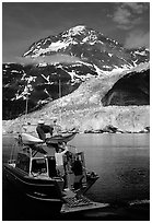 Kayakers unloading from the water taxi at Black Sand Beach. Prince William Sound, Alaska, USA (black and white)