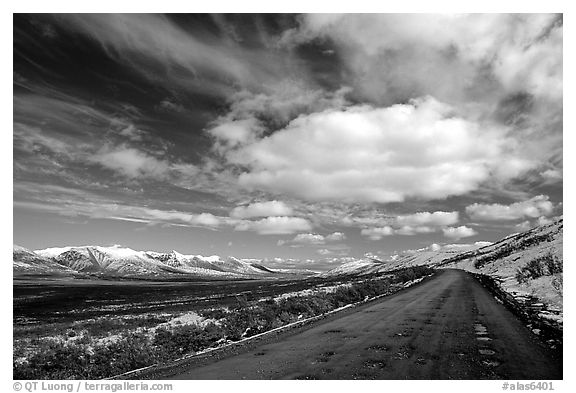 Denali Highway under large white clouds. Alaska, USA