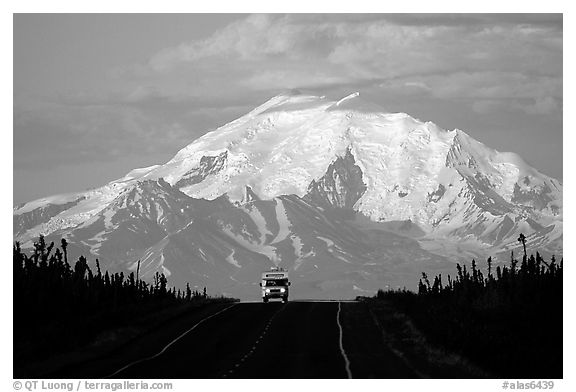 Car on road with a peak of the Wrangell range in the background. Glenn Highway, Central Alaska, USA