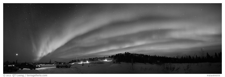 Northern Lights streaking above cars and cabin at Cleary Summit. Alaska, USA (black and white)