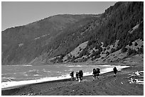 Backpackers on black sand beach and King Range, Lost Coast. California, USA (black and white)