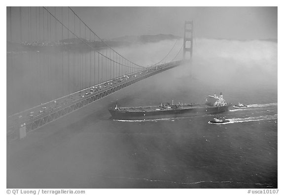 Tanker ship cruising under the Golden Gate Bridge in the fog. San Francisco, California, USA (black and white)