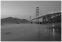 Golden Gage bridge at dusk, reflected in wet sand at East Baker Beach. San Francisco, California, USA (black and white)