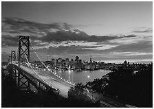 Bay Bridge and city skyline with lights at sunset. San Francisco, California, USA (black and white)