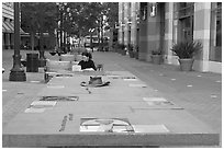 Woman sitting at a commemorative table in a downtown alley. San Jose, California, USA (black and white)