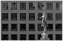 Statue on Admiral Dewey memorial column in front of modern building. San Francisco, California, USA (black and white)