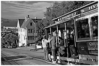 Cable car plunging with people clinging on Hyde Street, late afternoon. San Francisco, California, USA (black and white)