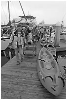 Sea kayaks and passengers awaiting loading on tour boat. California, USA (black and white)