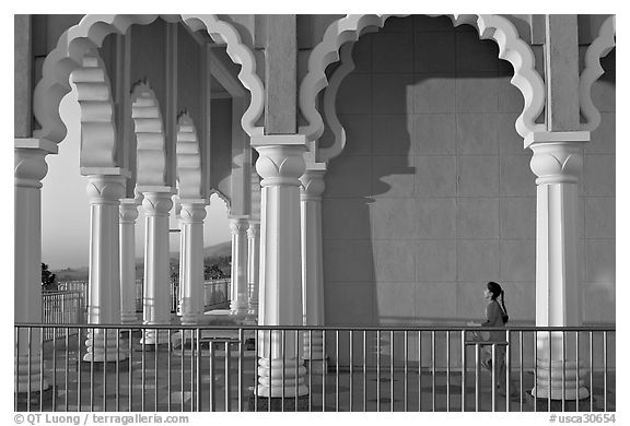 Indian girl running amongst columns of the Sikh Temple. San Jose, California, USA (black and white)