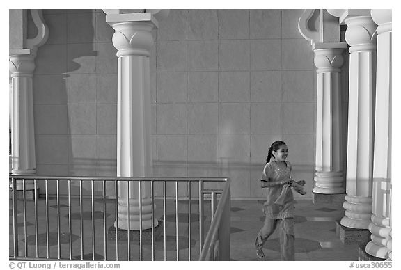 Indian girl running in the Sikh Gurdwara Temple, late afternoon. San Jose, California, USA