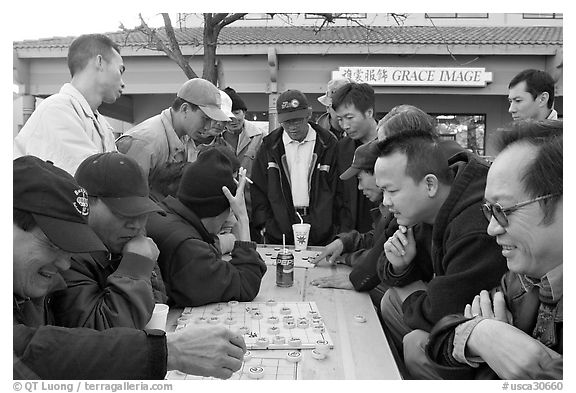 Vietnamese immigrants at a Chinese chess game. San Jose, California, USA (black and white)