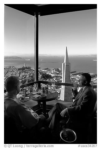 Businessmen with a bottle of Champagne in the Carnelian Room with panoramic view of the City. San Francisco, California, USA