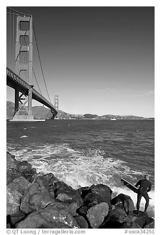 Surfer poised to jump in water below the Golden Gate Bridge. San Francisco, California, USA