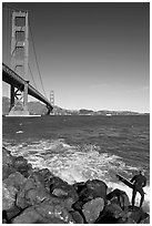 Surfer poised to jump in water below the Golden Gate Bridge. San Francisco, California, USA (black and white)