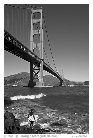 Surfer and wave below the Golden Gate Bridge. San Francisco, California, USA (black and white)