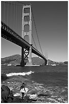 Surfer and wave below the Golden Gate Bridge. San Francisco, California, USA (black and white)