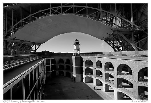 Fort Point courtyard, lighthouse,  and arch of the Golden Gate Bridge. San Francisco, California, USA (black and white)
