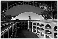 Fort Point courtyard, lighthouse,  and arch of the Golden Gate Bridge. San Francisco, California, USA ( black and white)