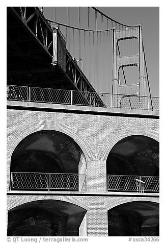 Arched galleries of Fort Point and Golden Gate Bridge pillar. San Francisco, California, USA (black and white)