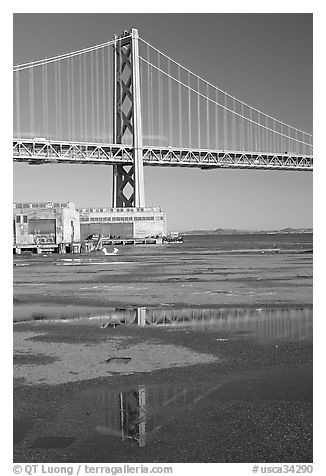 Bay Bridge reflected in water puddles. San Francisco, California, USA (black and white)