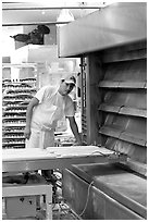 Baker loading loafs of bread into oven. San Francisco, California, USA (black and white)