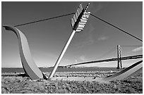 Modern sculputure called Cupid's arrow, framing the Bay Bridge. San Francisco, California, USA (black and white)