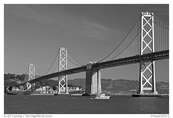 Cargo ship passing below the Bay Bridge. San Francisco, California, USA