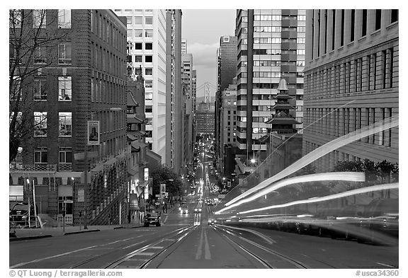 Cable-car rails,  Chinatown, Financial district, and Bay Bridge seen on California street. San Francisco, California, USA (black and white)