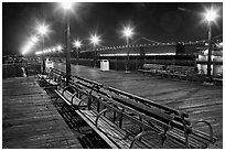 Benches and lights on Pier 7 with Bay Bridge in background, evening. San Francisco, California, USA (black and white)