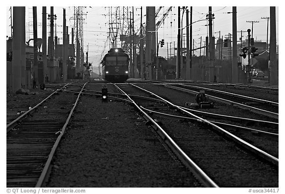 Railroad tracks, train, and power lines, sunrise. San Diego, California, USA