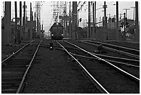 Railroad tracks, train, and power lines, sunrise. San Diego, California, USA (black and white)