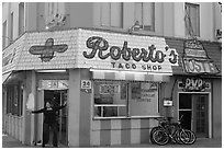 Woman exiting taco shop, Pacific Beach. San Diego, California, USA ( black and white)