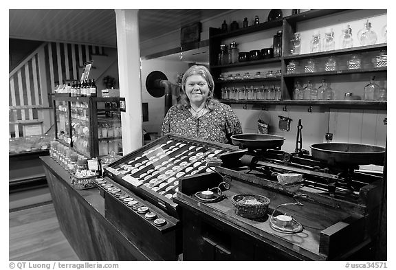 Woman standing behind counter of apothicary store, Old Town. San Diego, California, USA (black and white)