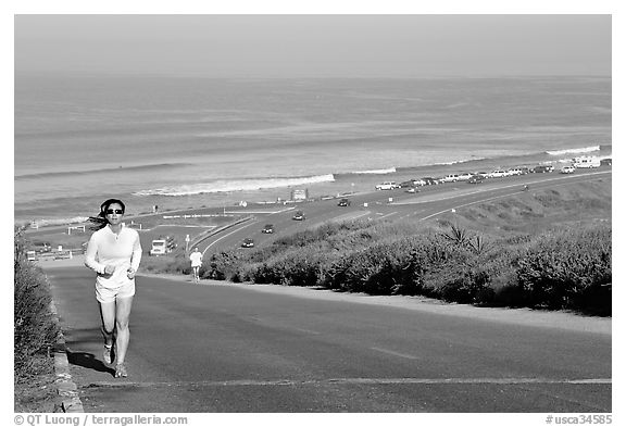Woman jogging on raod,  Torrey Pines State Preserve. La Jolla, San Diego, California, USA (black and white)