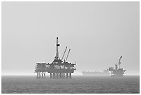 Off-shore drilling platforms and tanker. Huntington Beach, Orange County, California, USA (black and white)