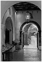 Corridor with candles next to the Serra Chapel. San Juan Capistrano, Orange County, California, USA (black and white)