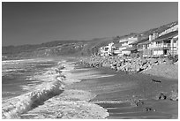 Surf and beachfront houses near Rincon Island. California, USA (black and white)