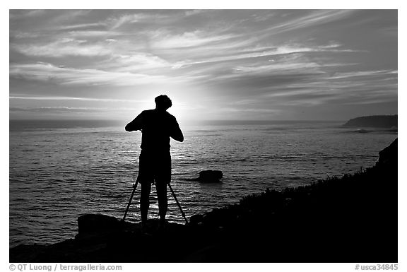 Photographer on cliffs at sunset. Santa Cruz, California, USA (black and white)